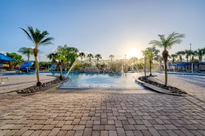 a resort with palm trees and a swimming pool at Spacious 6BR family villa, 10 min to Disney, private pool, resort waterpark in Kissimmee