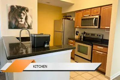 a kitchen with a lion picture on the wall at Lion King-themed condo near Disney, Sea World, Universal and OCCC with pool, spa, restaurants, shuttle, private balcony, and the BEST view of fireworks shows in Orlando