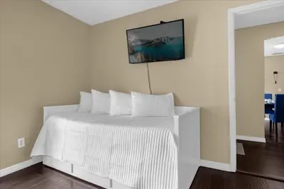 a bedroom with a white bed with a picture on the wall at 5Bd 2 Bath with Gameroom & Pool 1 story House in Orlando
