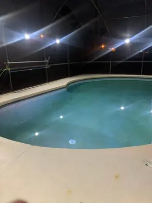 an empty swimming pool at night with lights at 5Bd 2 Bath with Gameroom & Pool 1 story House in Orlando