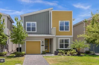 a house with a yellow garage at 5 Bedrroms 5 Bathrooms Storey Lake 2739 Bd in Kissimmee