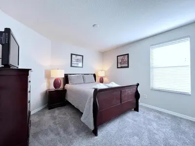 a bedroom with a bed with two lamps and a window at Luxurious 6Bd Pool Haven Refreshing and Chic-4464N home in Kissimmee