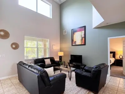 a living room with two leather chairs and a couch at Luxurious 6Bd Pool Haven Refreshing and Chic-4464N home in Kissimmee