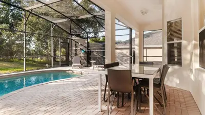 a dining room with a table and a swimming pool at The Skywalker in Orlando