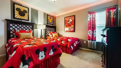 a bedroom with two beds with red comforters at The Skywalker in Orlando