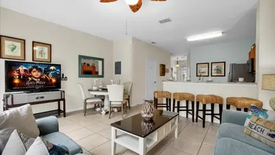 a living room with a couch and a dining room at The Cozy Cabin in Orlando