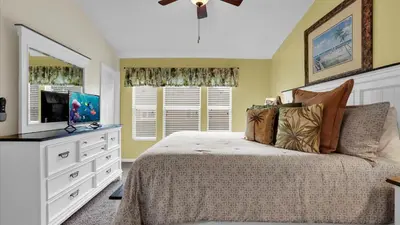 a bedroom with a bed with a dresser and a television at The Cozy Cabin in Orlando