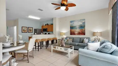 a living room with a blue couch and a table at The Cozy Cabin in Orlando