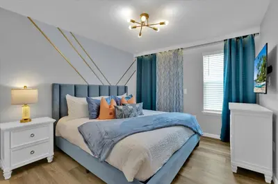 a bedroom with a blue bed and blue curtains at Villa Grande in Orlando