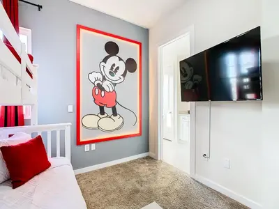 a bedroom with a mickey mouse painting on the wall at Fabulous Paradise 3BR Townhouse near Disney and outlets in Orlando