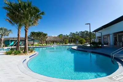 a large swimming pool with palm trees in a resort at Luxury Stay Near Disney Storey Lake Resort 2568 in Kissimmee