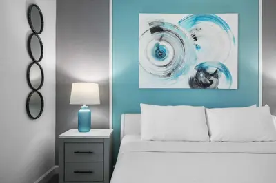 a bedroom with a white bed and a blue wall at Lake View Cozy Home w/ Pool & Games Near Disney in Kissimmee