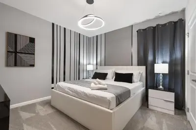 a bedroom with a white bed with black curtains at Luxury 12BR Villa w/ Pool & Spa Near Disney in Kissimmee