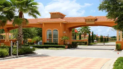 an orange building with an arch in a courtyard at Luxury 12BR Villa w/ Pool & Spa Near Disney in Kissimmee