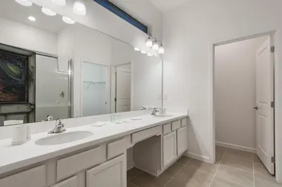 a bathroom with two sinks and a large mirror at Luxury 12BR Villa w/ Pool & Spa Near Disney in Kissimmee