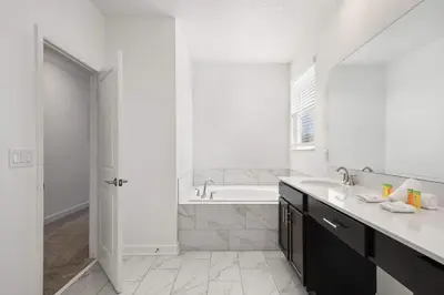 a white bathroom with a tub and a sink at Luxurious Resort Home Near Disney & Shopping! in Kissimmee