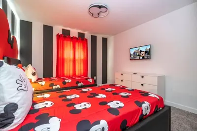a bedroom with a red comforter with cows on it at Fantastic Mickey house Waterpark near Disney 2572 in Kissimmee