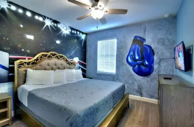 a bedroom with a bed in a room with a blue wall at All Vacation Mansion w Spa-Pool-Cinema Sleep 40 in Kissimmee