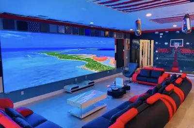 a living room with a large screen tv at All Vacation Mansion w Spa-Pool-Cinema Sleep 40 in Kissimmee