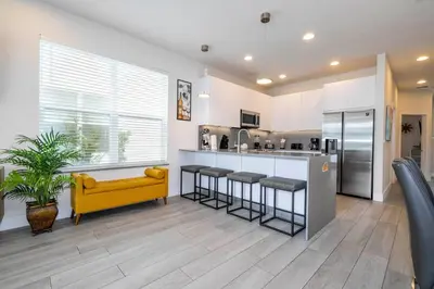 a kitchen with a yellow couch and a counter at Comfortable home Near Disney & Private Pool 17414 in Orlando