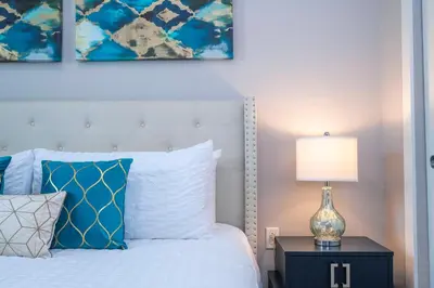 a bedroom with a bed and a lamp on a night stand at Stunning Villa 5 min to Disney in Orlando