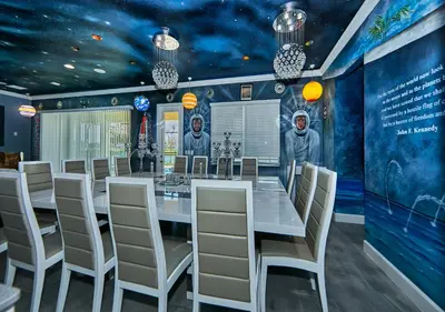 a dining room with a long table and chairs at Remarkable Mansion Sleep 36 Cinema-Bowling Alley & More in Kissimmee