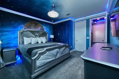 a bedroom with a bed in a blue room at Remarkable Mansion Sleep 36 Cinema-Bowling Alley & More in Kissimmee
