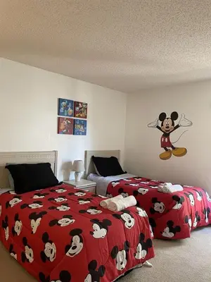 a bedroom with two beds with a mickey mouse blanket at 2974 Viscount Villa 3bed Pool in Kissimmee