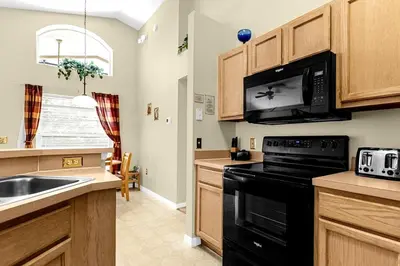 a kitchen with a sink and a black microwave at 1061 Lake Berkley 4 Bed with Pool in Kissimmee