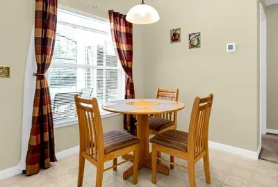 a dining room with a table and chairs and a window at 1061 Lake Berkley 4 Bed with Pool in Kissimmee