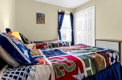 a bedroom with two beds with a colorful quilt at 1061 Lake Berkley 4 Bed with Pool in Kissimmee