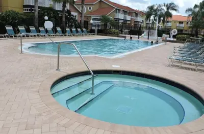 a swimming pool at a resort with chairs at 1061 Lake Berkley 4 Bed with Pool in Kissimmee