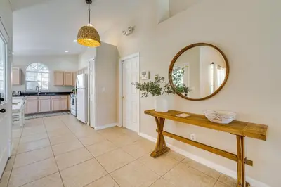 a kitchen with a table and a mirror on the wall at 11 Mi to WDW Kissimmee House with Private Pool! in Kissimmee