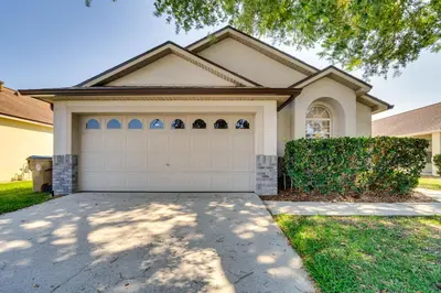 a house with a garage in front of it at 11 Mi to WDW Kissimmee House with Private Pool! in Kissimmee