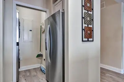 a stainless steel refrigerator in a room with a hallway at Sunshine Oasis - Orlando Lakefront Luxury in Orlando