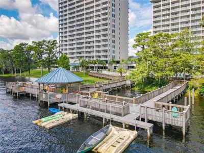 a dock with a boat on the water with buildings at Sunshine Oasis - Orlando Lakefront Luxury in Orlando