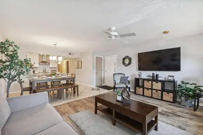 a living room with a couch and a table at SPECTACULAR, NEW Professional Decor, Near Dis, NO Steps, Pool, Patio, LOW Rates! in Kissimmee