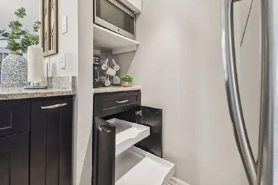 a kitchen with black cabinets and a sink at SPECTACULAR, NEW Professional Decor, Near Dis, NO Steps, Pool, Patio, LOW Rates! in Kissimmee