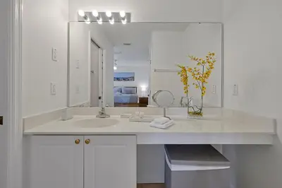 a white bathroom with a sink and a mirror at Spacious Condo W/ Pool,Gym near Disney & Seaworld in Kissimmee