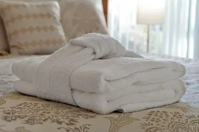a pile of white towels sitting on a bed at Spacious Condo W/ Pool,Gym near Disney & Seaworld in Kissimmee