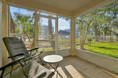 a screened in porch with a chair and a window at Spacious Condo W/ Pool,Gym near Disney & Seaworld in Kissimmee