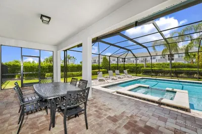 a patio with a table and chairs and a swimming pool at Spacious Home With Private Pool Near Disney With Waterpark & Resort Access At Encore Resort - 7720Ff in Kissimmee