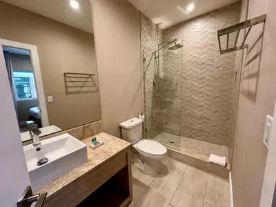 a bathroom with a shower and a toilet and a sink at Luxury Home in Orlando with private Hot Tub - 7 Min from Disney Parks - 3 bedrooms and 4 bathrooms! in Orlando