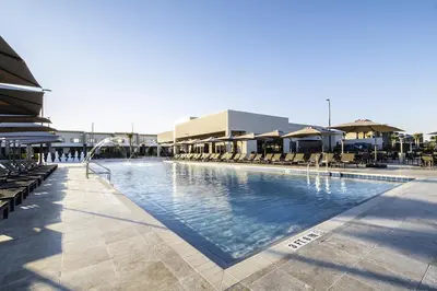 a large swimming pool with chairs and umbrellas at Luxury Home in Orlando with private Hot Tub - 7 Min from Disney Parks - 3 bedrooms and 4 bathrooms! in Orlando