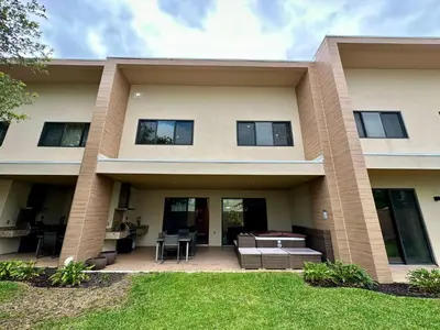 a large house with a patio and grass at Luxury Home in Orlando with private Hot Tub - 7 Min from Disney Parks - 3 bedrooms and 4 bathrooms! in Orlando