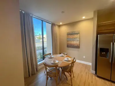 a dining room with a table and chairs and a large window at Luxury Home in Orlando with private Hot Tub - 7 Min from Disney Parks - 3 bedrooms and 4 bathrooms! in Orlando