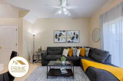 a living room with a couch and a ceiling fan at Cozy 4bdhome By Lake Prime Location Disney in Kissimmee