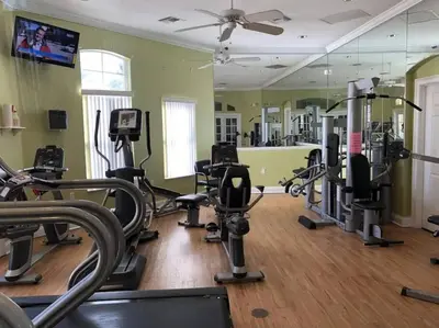 a gym with several treadmills and cardio machines at Disney Villa Magical Retreat Private Pool, LakeView & Game Room in Kissimmee