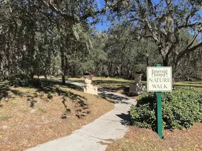 a sign in a park next to a walkway at Disney Villa Magical Retreat Private Pool, LakeView & Game Room in Kissimmee