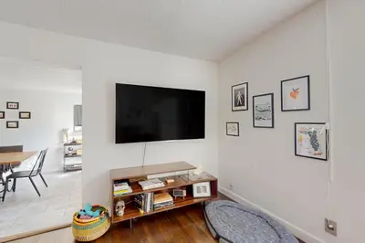 a living room with a flat screen tv on a white wall at Boat and Fish! Lake Druid Gem with Dog-Friendly Yard in Orlando